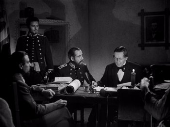 Movie still from “Juarez” (1939), directed by William Dieterle – A group of men sitting around a table; Medium shot, Over the shoulder angle