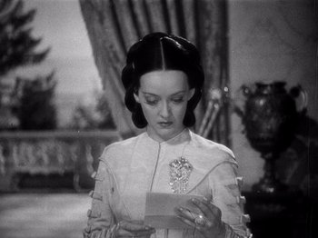 Movie still from “Juarez” (1939), directed by William Dieterle – A woman in a white dress holding an open envelope; Close Up shot, High angle