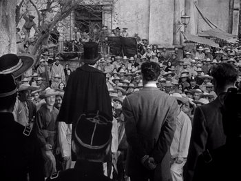 Movie still from “Juarez” (1939), directed by William Dieterle – A crowd of people standing in front of a building; Wide shot, High angle