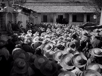 Movie still from “Juarez” (1939), directed by William Dieterle – A large group of people wearing hats in front of a building; Extreme Wide shot, High angle