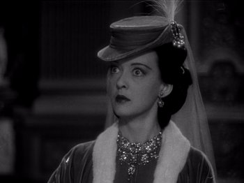 Movie still from “Juarez” (1939), directed by William Dieterle – A woman wearing a hat with a veil on top of her head; Close Up shot, Over the shoulder angle