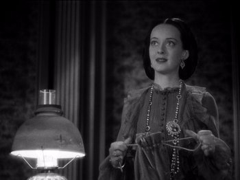 Movie still from “Juarez” (1939), directed by William Dieterle – A black - and - white photo of a woman holding a pair of shears; Close Up shot, High angle