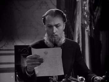 Movie still from “Juarez” (1939), directed by William Dieterle – A black and white photo of a man looking at a piece of paper; Close Up shot, Low angle