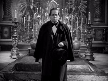 Movie still from “Juarez” (1939), directed by William Dieterle – A black and white photo of a man in a long black coat; Medium shot, Low angle