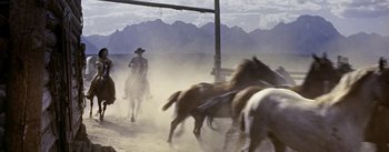 Movie still from “Jubal” (1956), directed by Delmer Daves – A man on a horse in the middle of a dirt field; Wide shot, Low angle