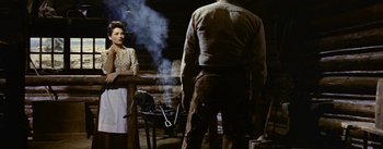 Movie still from “Jubal” (1956), directed by Delmer Daves – A man and a woman standing in front of an outdoor grill; Medium shot, Low angle