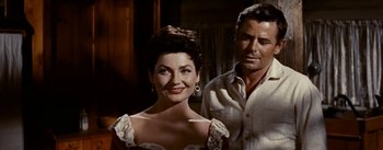 Movie still from “Jubal” (1956), directed by Delmer Daves – A man and a woman standing next to each other; Close Up shot, Low angle