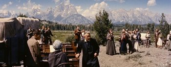 Movie still from “Jubal” (1956), directed by Delmer Daves – An old man and a group of people standing in a field; Wide shot, Over the shoulder angle