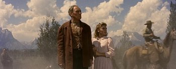 Movie still from “Jubal” (1956), directed by Delmer Daves – An older man and a young woman standing next to each other; Medium shot, Low angle