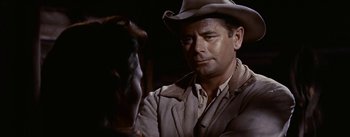 Movie still from “Jubal” (1956), directed by Delmer Daves – A man wearing a cowboy hat and a jacket; Close Up shot, Over the shoulder angle