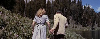Movie still from “Jubal” (1956), directed by Delmer Daves – A man and a woman holding hands while standing next to each other; Medium shot, Over the shoulder angle