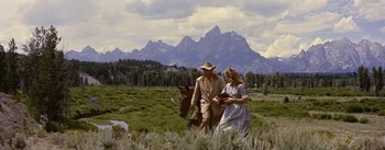 Movie still from “Jubal” (1956), directed by Delmer Daves – A man and a woman walking a horse through a field; Wide shot, Low angle
