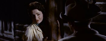 Movie still from “Jubal” (1956), directed by Delmer Daves – A woman standing next to a man wearing a hat; Close Up shot, Over the shoulder angle