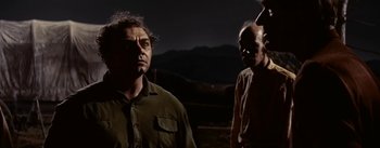 Movie still from “Jubal” (1956), directed by Delmer Daves – A man standing next to another man on a field; Medium shot, Over the shoulder angle