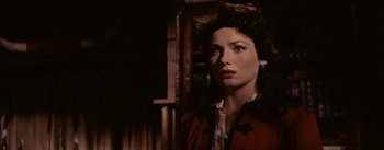 Movie still from “Jubal” (1956), directed by Delmer Daves – A woman in a red jacket looking at the camera; Close Up shot, Over the shoulder angle