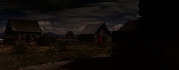 Movie still from “Jubal” (1956), directed by Delmer Daves – A person standing in front of a barn at night; Extreme Wide shot, Low angle