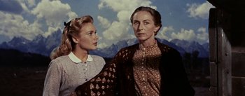 Movie still from “Jubal” (1956), directed by Delmer Daves – Two women standing next to each other in front of mountains; Medium shot, Low angle