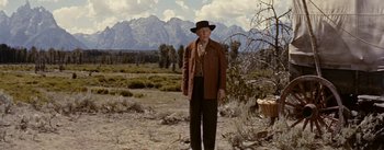 Movie still from “Jubal” (1956), directed by Delmer Daves – An old man in a cowboy hat standing in a field; Wide shot, Low angle
