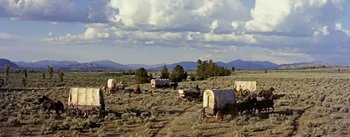 Movie still from “Jubal” (1956), directed by Delmer Daves – A group of covered wagons in the middle of a field; Extreme Wide shot, High angle