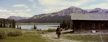 Movie still from “Jubal” (1956), directed by Delmer Daves – A man riding a horse down a dirt road; Extreme Wide shot, Over the shoulder angle