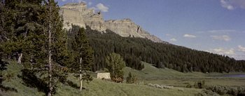 Movie still from “Jubal” (1956), directed by Delmer Daves – Two horses are standing in a field near a mountain; Extreme Wide shot, Low angle