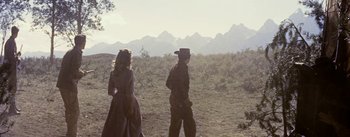 Movie still from “Jubal” (1956), directed by Delmer Daves – A man and a woman walking through a field; Wide shot, Low angle