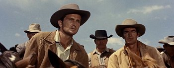 Movie still from “Jubal” (1956), directed by Delmer Daves – A group of men wearing cowboy hats in a field; Close Up shot, Low angle