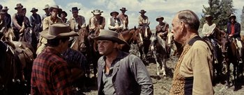 Movie still from “Jubal” (1956), directed by Delmer Daves – A group of men riding horses on a dirt field; Medium shot, Low angle