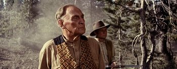 Movie still from “Jubal” (1956), directed by Delmer Daves – A man in a cowboy hat standing next to another man in a cowboy hat; Medium shot, Low angle