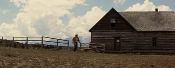 Movie still from “Jubal” (1956), directed by Delmer Daves – A man walking in front of an old cabin; Wide shot, Low angle