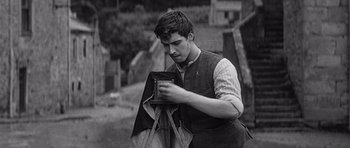 Movie still from “Jude” (1996), directed by Michael Winterbottom – A man holding a camera and taking a picture; Medium shot, Low angle