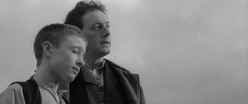 Movie still from “Jude” (1996), directed by Michael Winterbottom – A black and white photo of a man and a boy; Close Up shot, Low angle