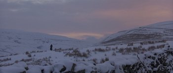 Movie still from “Jude” (1996), directed by Michael Winterbottom – A person standing on a snowy field near some mountains; Extreme Wide shot, Low angle