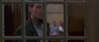 Movie still from “Jude” (1996), directed by Michael Winterbottom – A man looking through a window at a group of people; Close Up shot, Over the shoulder angle