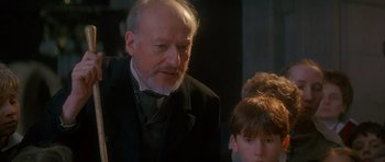 Movie still from “Jude” (1996), directed by Michael Winterbottom – An older man and a young boy in a black suit; Close Up shot, Over the shoulder angle