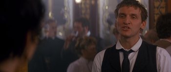 Movie still from “Jude” (1996), directed by Michael Winterbottom – A group of people standing in a room; Close Up shot, Over the shoulder angle