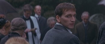 Movie still from “Jude” (1996), directed by Michael Winterbottom – A person wearing a suit and tie; Close Up shot, Over the shoulder angle