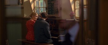 Movie still from “Jude” (1996), directed by Michael Winterbottom – A man and a woman sitting at a piano in a church; Medium shot, Over the shoulder angle