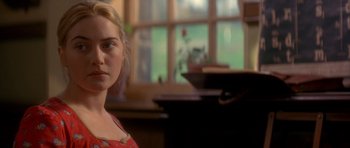 Movie still from “Jude” (1996), directed by Michael Winterbottom – A woman in a red dress standing in front of a piano; Close Up shot, Over the shoulder angle