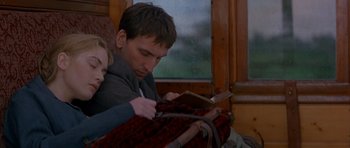 Movie still from “Jude” (1996), directed by Michael Winterbottom – A man sitting on a train while holding a book; Medium shot, Low angle