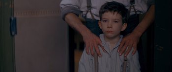 Movie still from “Jude” (1996), directed by Michael Winterbottom – A man helping a young boy to put on a tie; Close Up shot, Over the shoulder angle