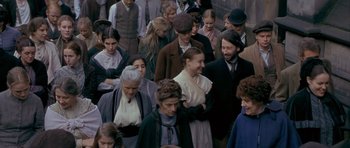 Movie still from “Jude” (1996), directed by Michael Winterbottom – A group of people standing around each other in a crowd; Medium shot, High angle