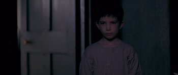 Movie still from “Jude” (1996), directed by Michael Winterbottom – A young boy standing in a dark room; Close Up shot, Over the shoulder angle