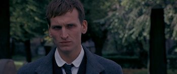 Movie still from “Jude” (1996), directed by Michael Winterbottom – A person wearing a suit and tie; Close Up shot, Over the shoulder angle