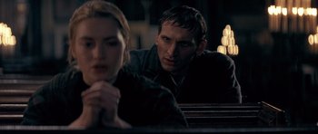 Movie still from “Jude” (1996), directed by Michael Winterbottom – A man and a woman sitting next to each other in front of candles; Close Up shot, Over the shoulder angle