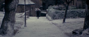 Movie still from “Jude” (1996), directed by Michael Winterbottom – A man walking down a snow covered street; Extreme Wide shot, High angle