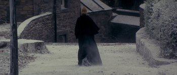 Movie still from “Jude” (1996), directed by Michael Winterbottom – A person walking in the middle of a snowy field; Wide shot, High angle