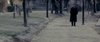 Movie still from “Jude” (1996), directed by Michael Winterbottom – A person is walking down a path in a cemetery; Wide shot, High angle