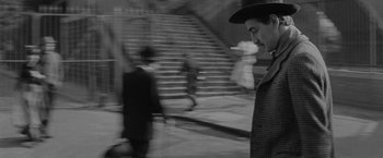Movie still from “Jules and Jim” (1962), directed by François Truffaut – Black and white photograph of people walking down a street; Medium shot, High angle