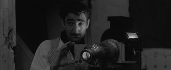 Movie still from “Jules and Jim” (1962), directed by François Truffaut – A black - and - white photo of a man looking at a camera; Close Up shot, Low angle